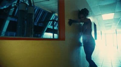 a woman leaning against a wall in a hallway