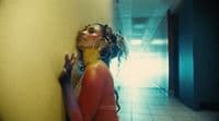 a woman leaning against a wall in a hallway