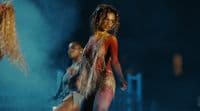 a woman in a bodysuit is dancing on stage