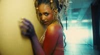 a woman with dreadlocks leaning against a wall