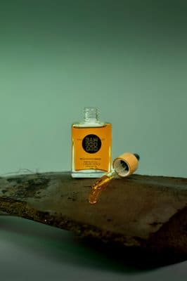 a bottle of oil sitting on top of a wooden table