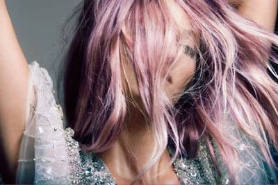 a woman with pink hair is posing for a picture