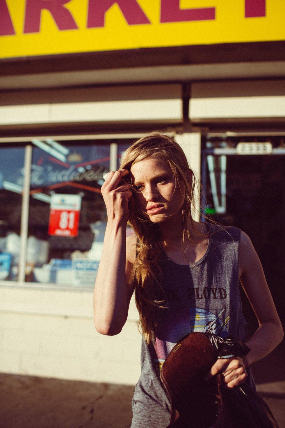 a woman standing in front of a market talking on a cell phone