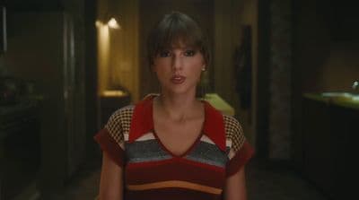 a woman standing in a room with a light on