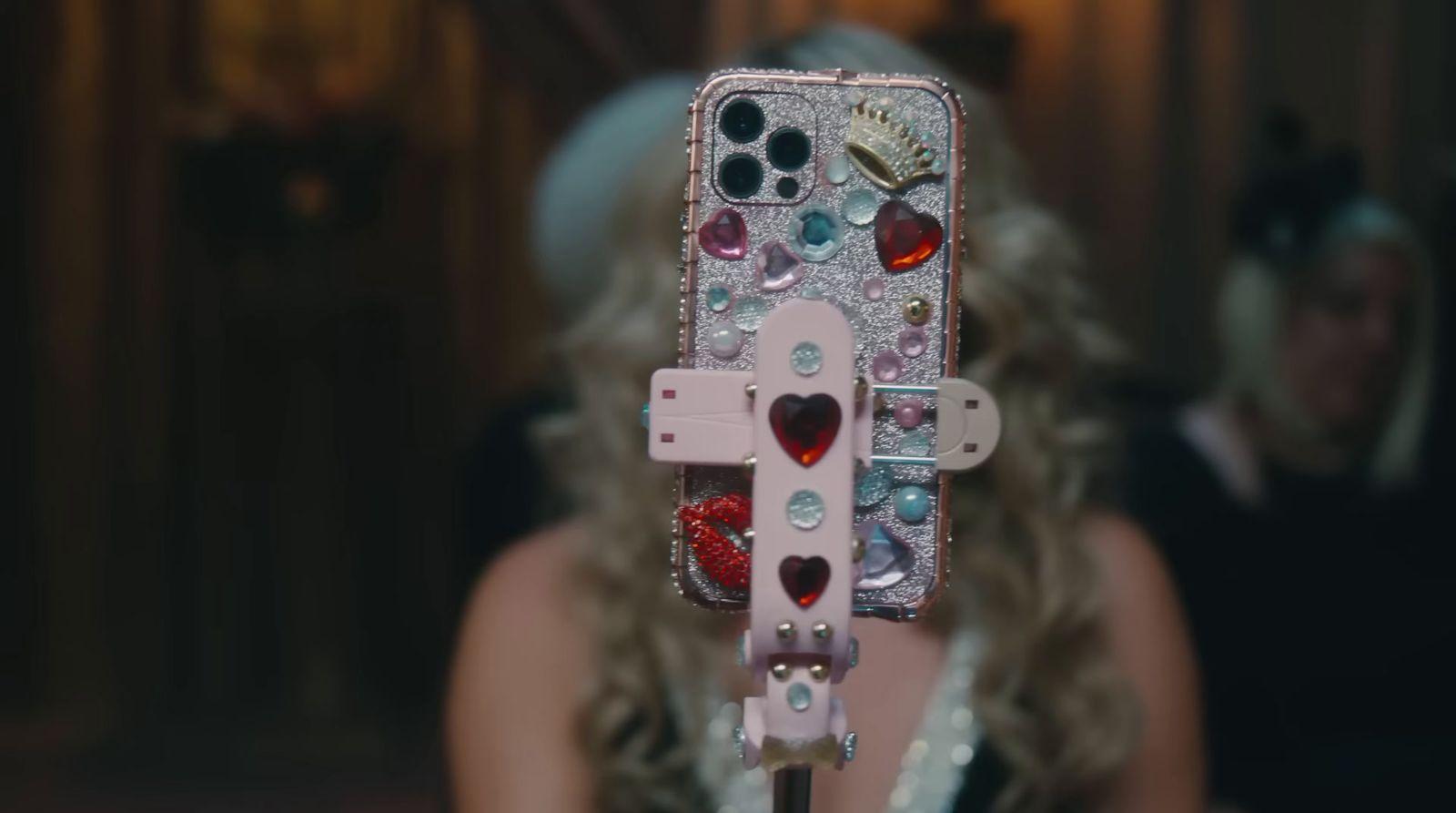 a woman holding a cell phone with a cross on it