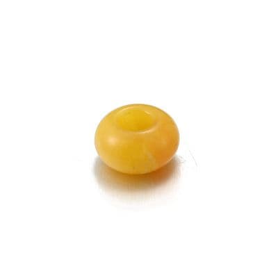 a yellow bead on a white background