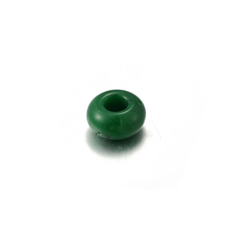 a green ceramic vase sitting on a white surface