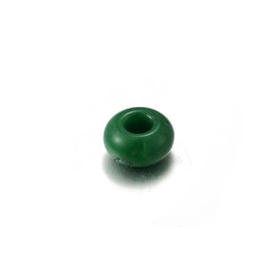a green ceramic vase sitting on a white surface