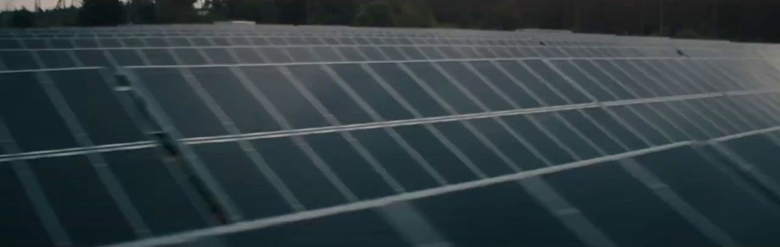 a large solar panel with trees in the background