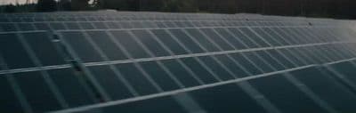 a large solar panel with trees in the background