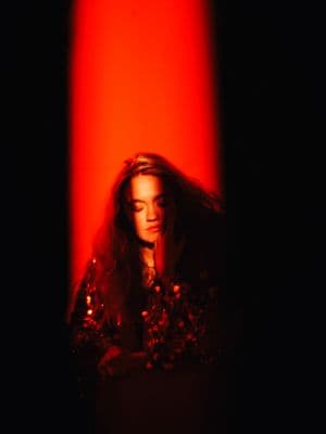 a woman standing in front of a red light