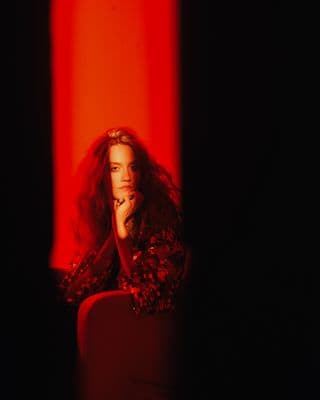 a woman sitting in a chair in a dark room