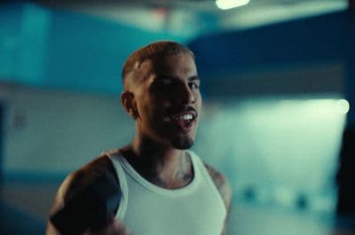 a man in a tank top holding a tennis racquet