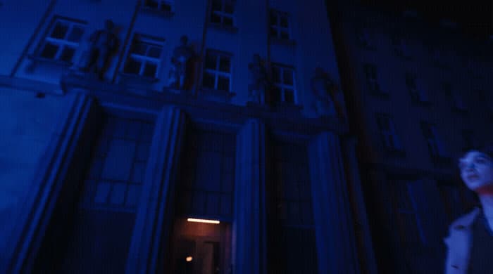 a woman standing in front of a tall building