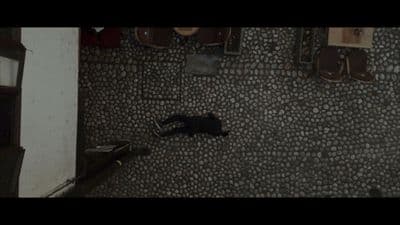 a person laying on the ground next to a wall