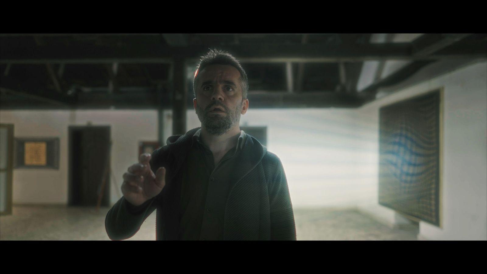 a man in a black jacket is standing in a room