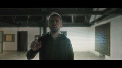a man in a black jacket is standing in a room