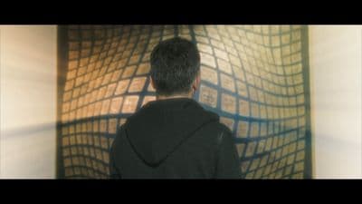 a man standing in front of a wall with a painting on it