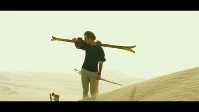 a man carrying two skis on his back