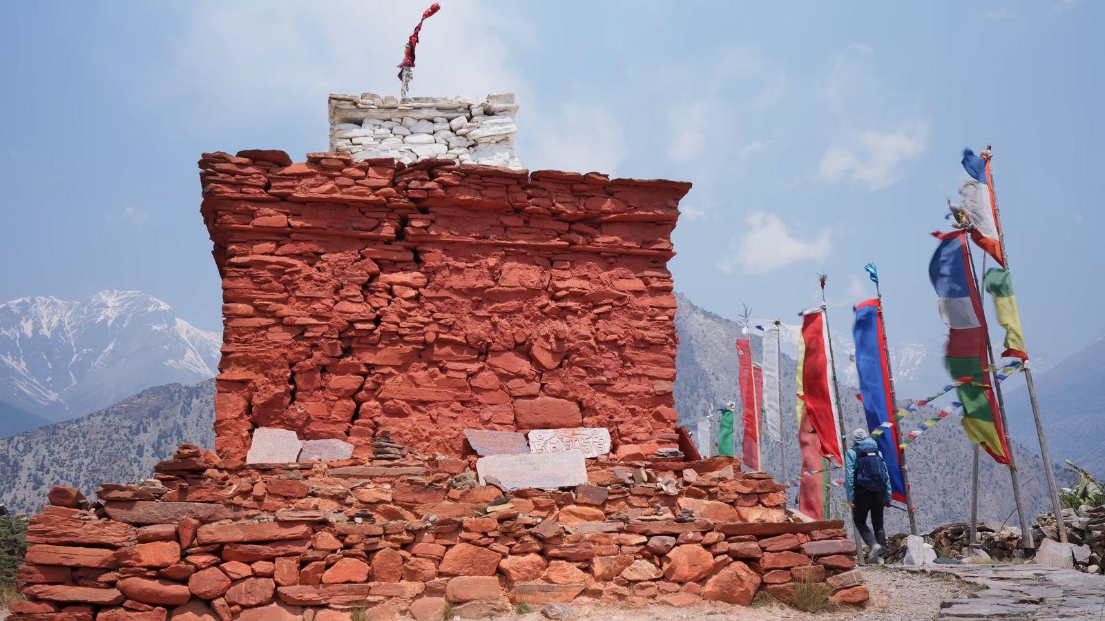 a stone structure with flags on top of it
