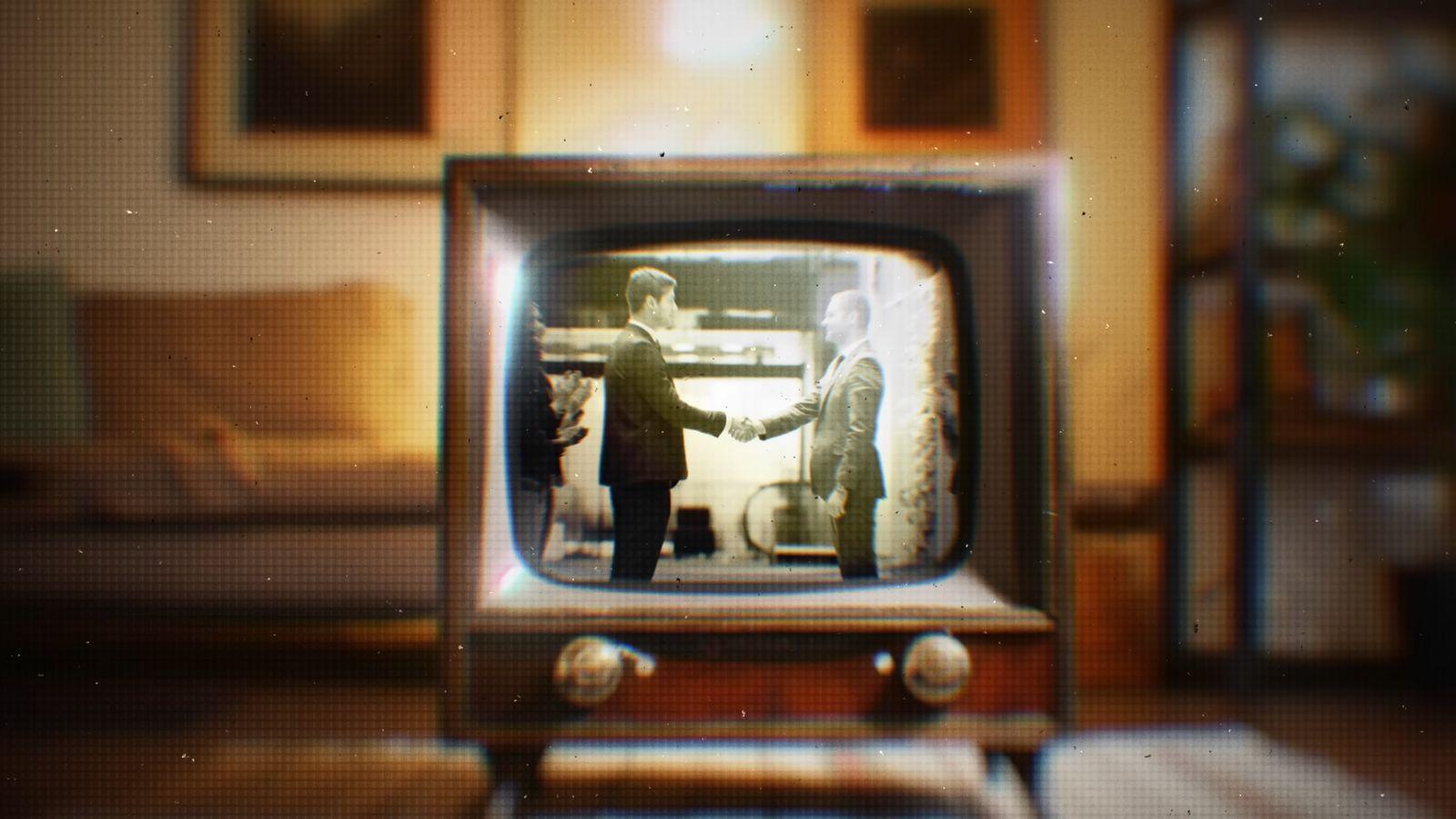 an old television with two people shaking hands