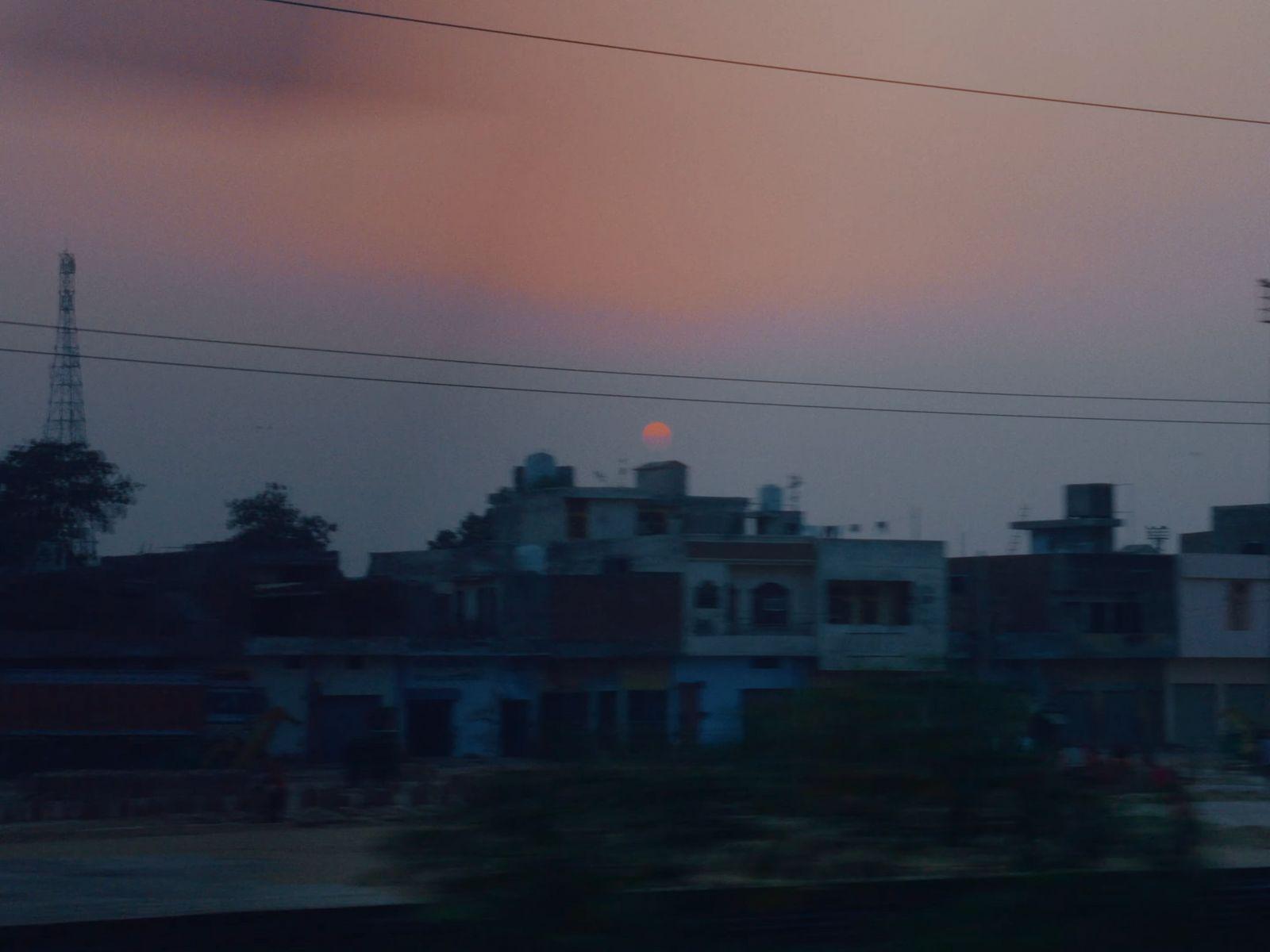 the sun is setting in the distance over a city