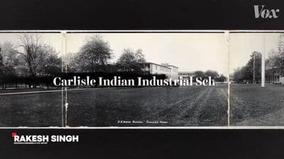 a black and white photo of a field with a house in the background