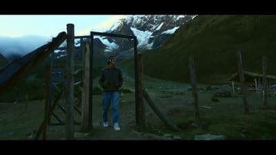 a man standing in front of a wooden structure