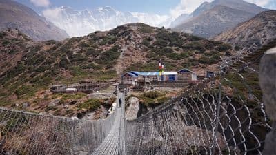 a suspension bridge with a mountain in the background