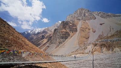 a suspension bridge in the middle of a mountain range