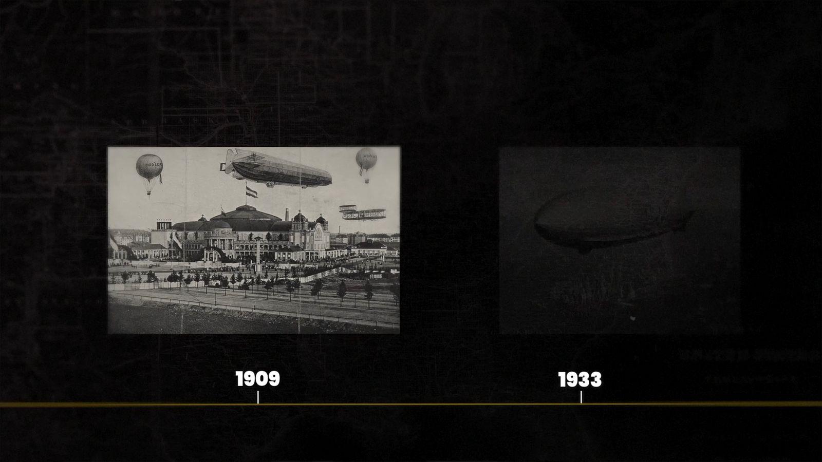 a black and white photo of a city with hot air balloons