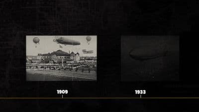 a black and white photo of a city with hot air balloons