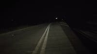 a car driving down a dark road at night