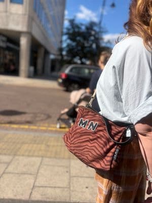 a woman carrying a purse on a city street