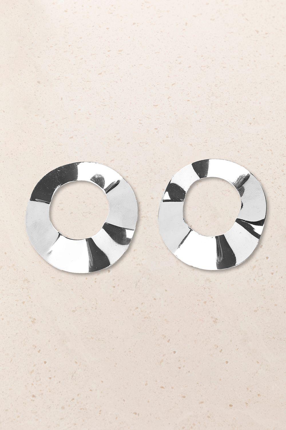 a pair of circular earrings on a beige background
