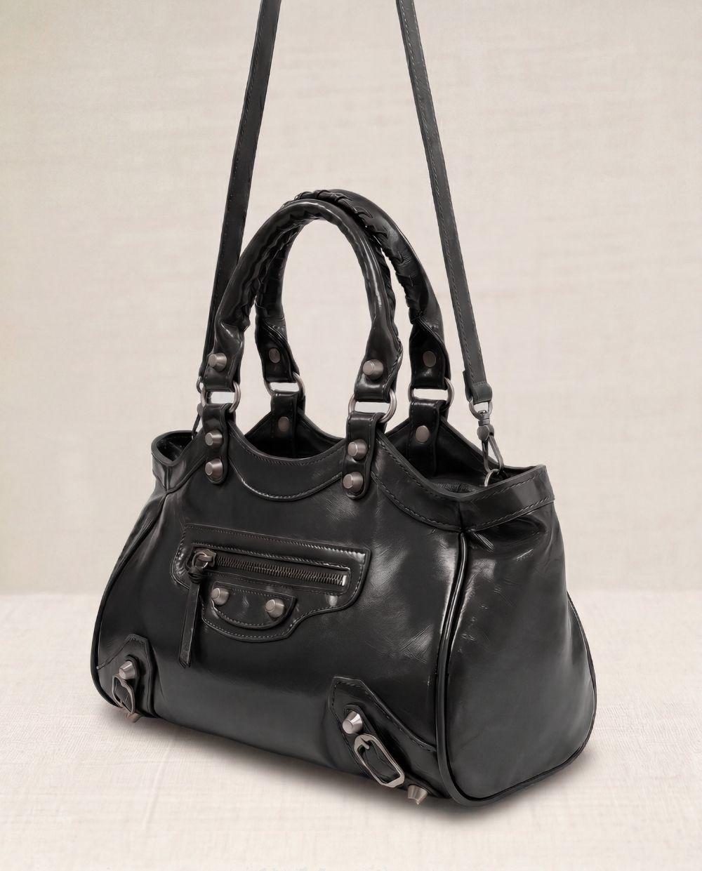 a black handbag with two straps hanging from it