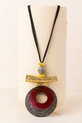 a necklace with a wooden object on it