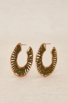 a pair of gold hoop earrings on a white background