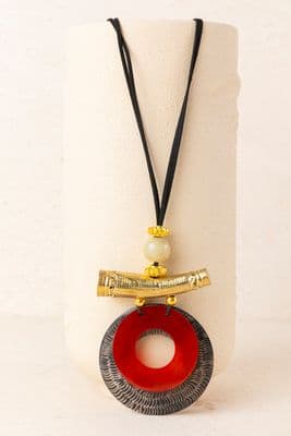 a white vase with a red and black necklace on it