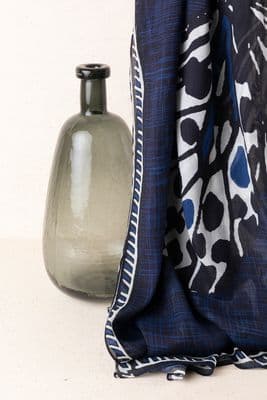 a vase sitting next to a scarf on a table