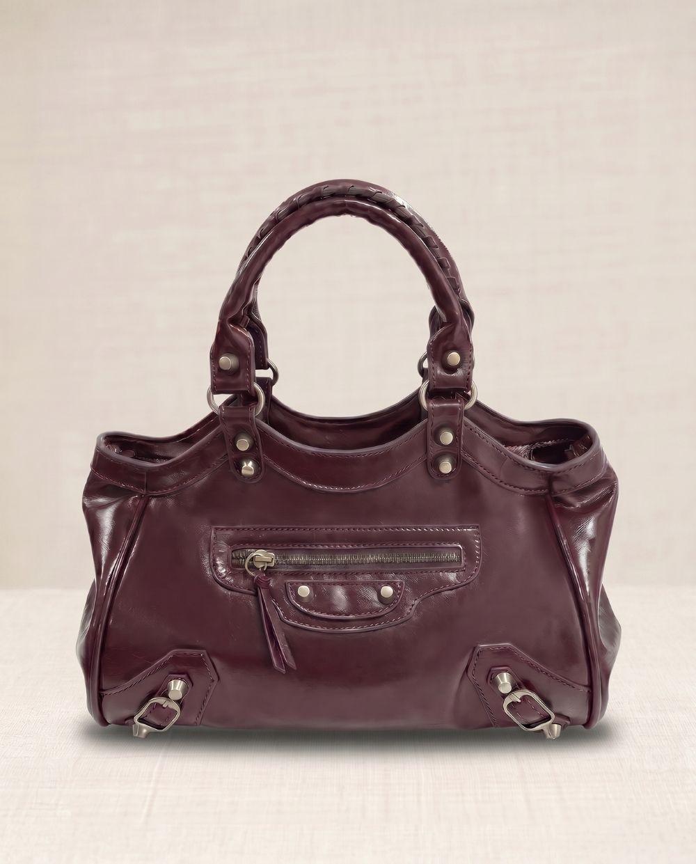 a purple handbag sitting on top of a white table
