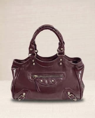 a purple handbag sitting on top of a white table