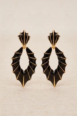 a pair of black and gold earrings
