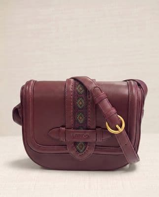 a maroon leather bag with a gold ring on the strap