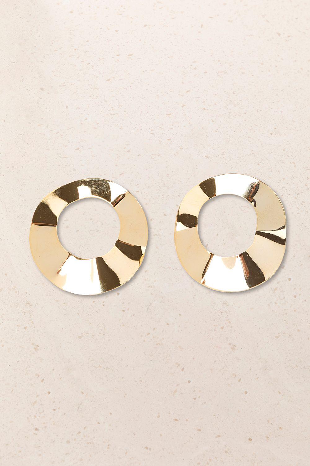 a pair of gold earrings on a white surface