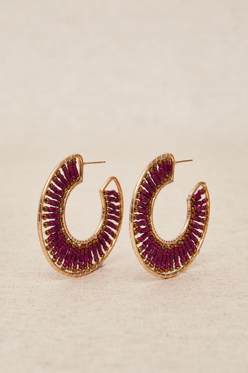 a pair of gold and red hoop earrings