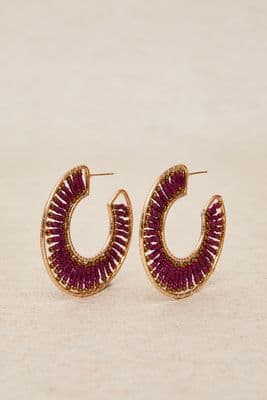 a pair of gold and red hoop earrings