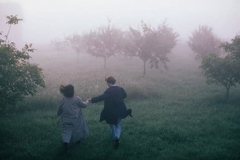 a couple of people that are walking in the grass