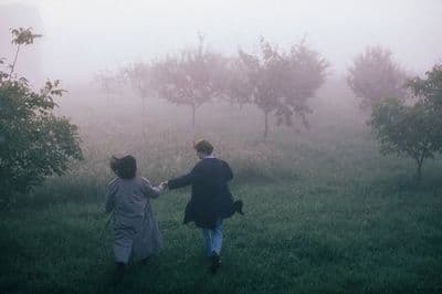 a couple of people that are walking in the grass