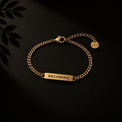 a gold bracelet with the words becoming engraved on it